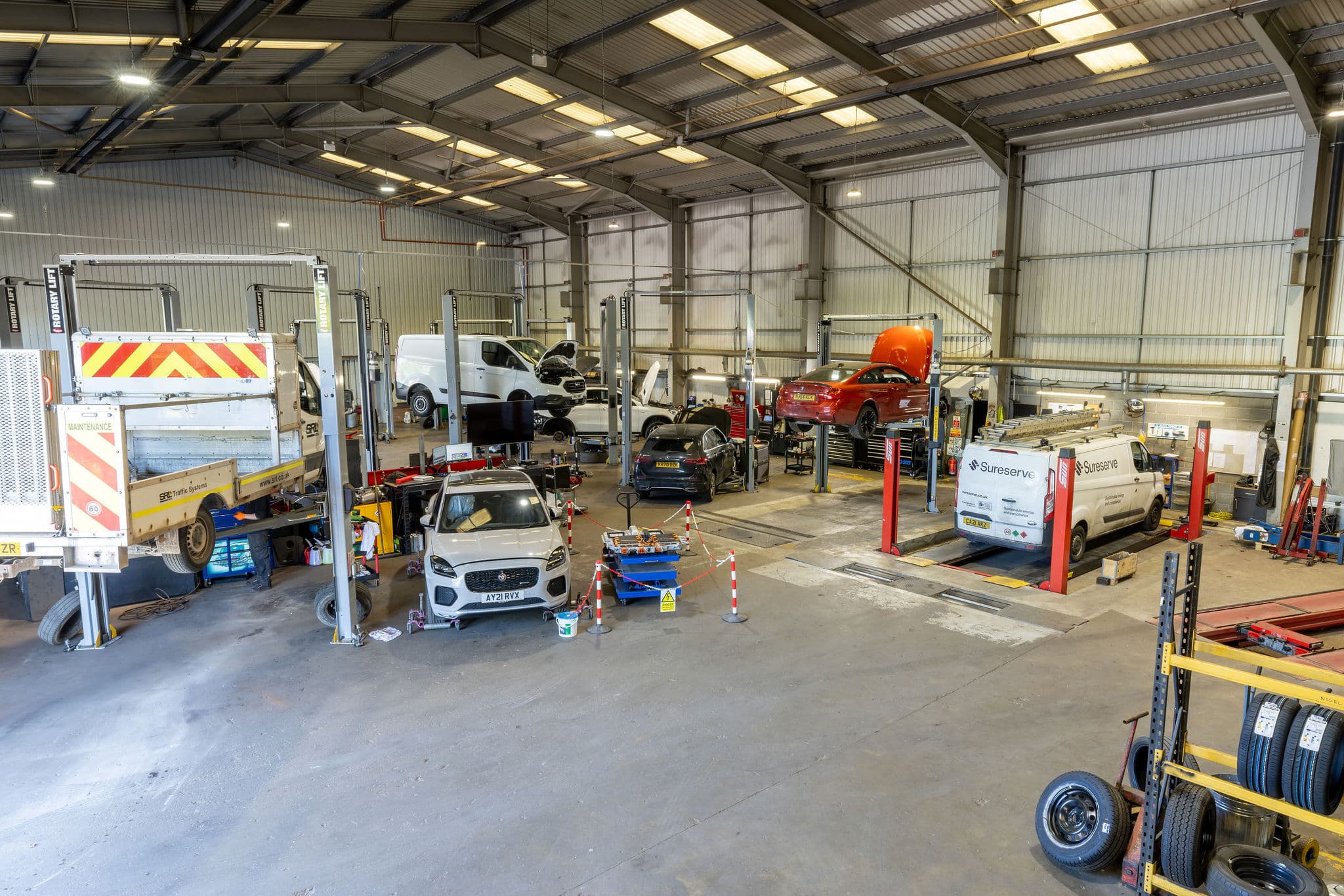 The Dack service workshop with vans and cars up on lifts across multiple bays